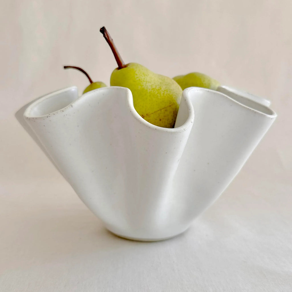 Large white high sided wave bowl styled on a dining table setting