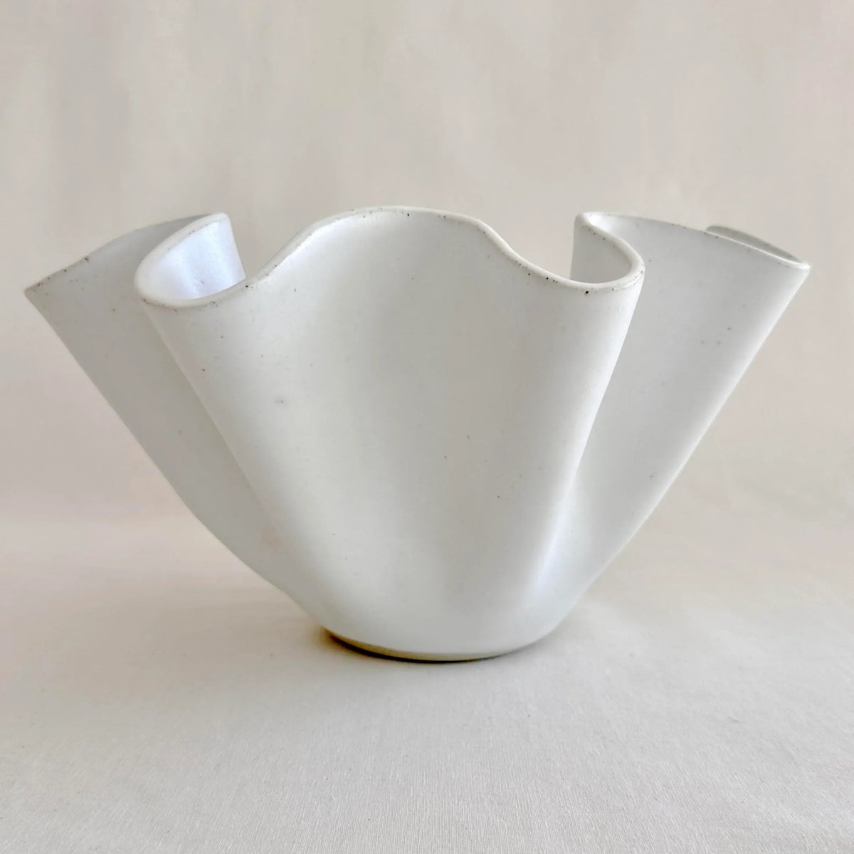 Angled view of the large white high sided wave bowl highlighting shadow and texture