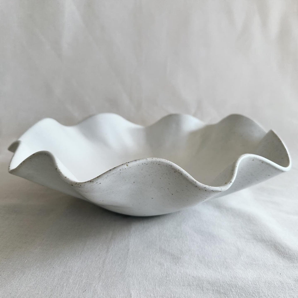 Close-up detail of the ruffled wave edge on the large white bowl